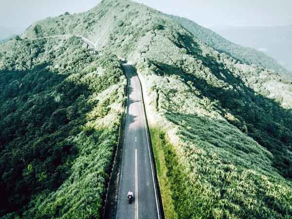 Picture Polo Motorrad und Sportswear GmbH Motorcycle on a road through a green hilly landscape